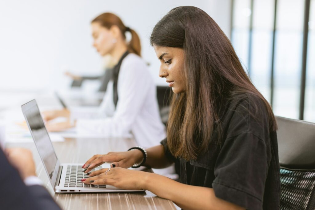 India business woman employee woking in office typing data in laptop computer